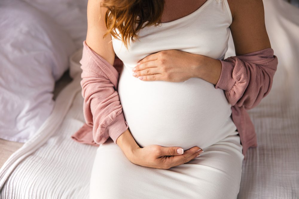 Schwangere Frau hält ihren Babybauch